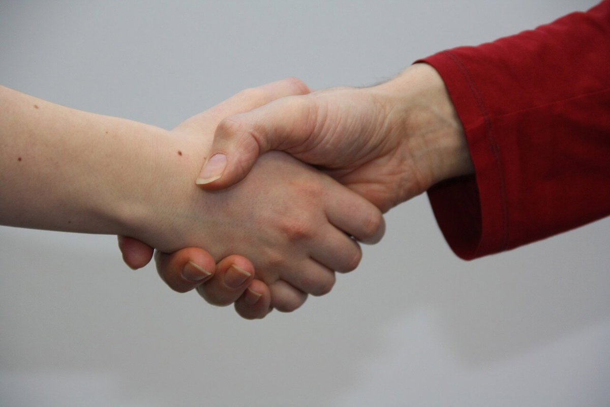 Zwei Menschen geben sich die Hand