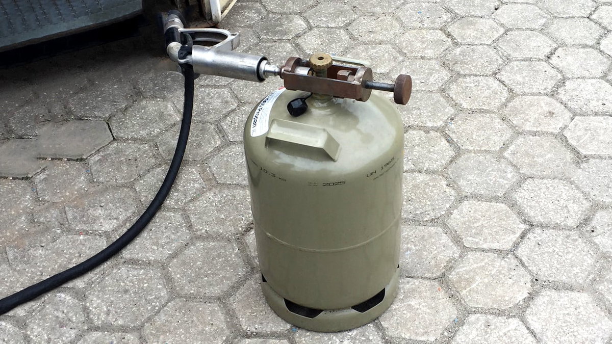 Eine deutsche Gasflasche, die in Portugal mit Adapter aufgefuellt wird
