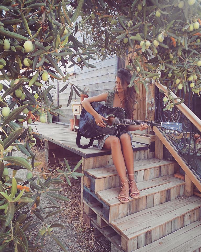 Frau mit Gitarre vor Tiny House in Andalusien