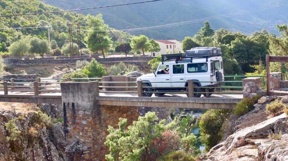 Ein Auto faehrt ueber eine Bruecke in einem kleinen Dorf in Frankreich