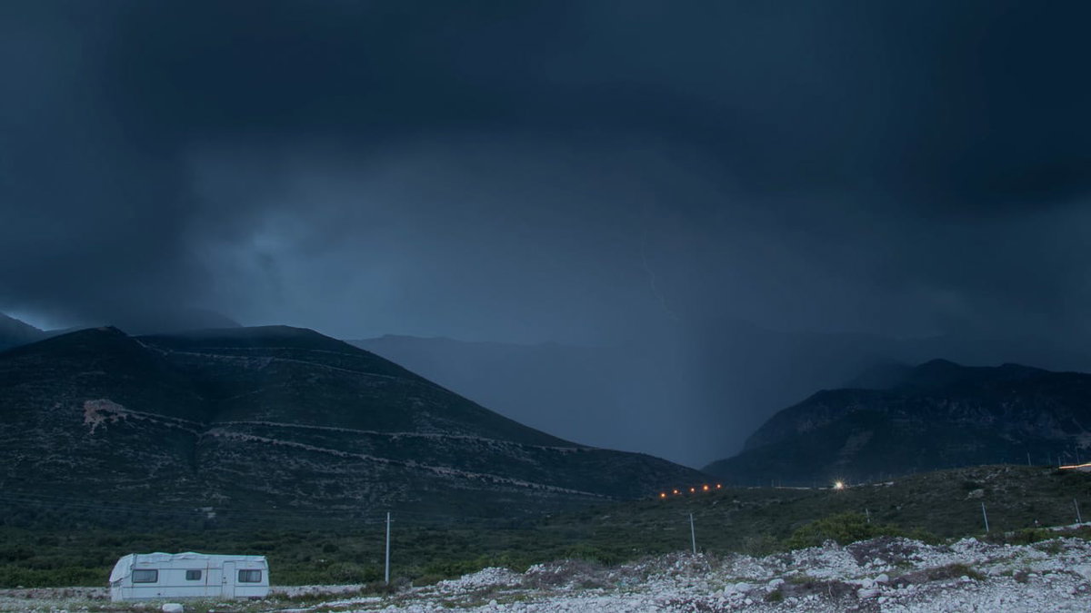 Ein Nachthimmel mit Gewitter und einem Wohnmobil