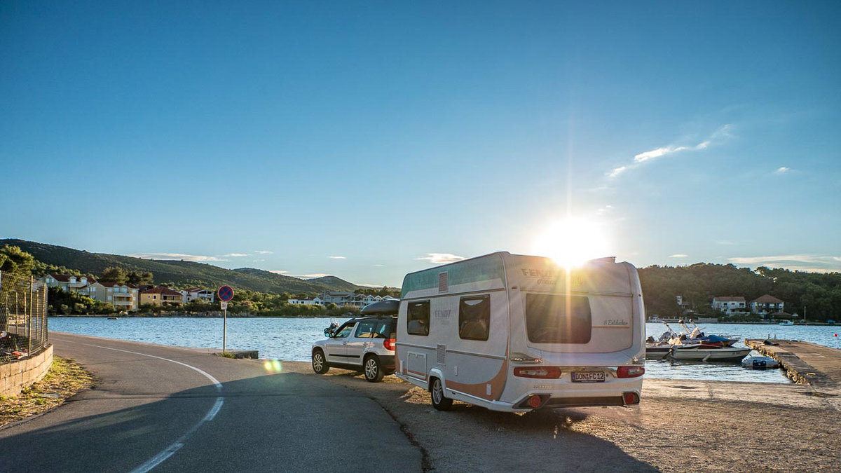 Wohnwagen und Zugfahrzeug am Meer beim Camping mit Wohnwagen