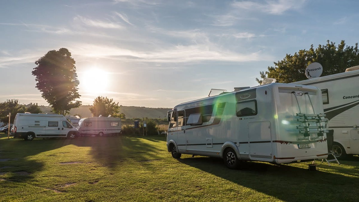 Campingtipps zum Sparen gibt es auch fuer Campingplaetze wie hier mit dem Wohnmobil auf einer Wiese