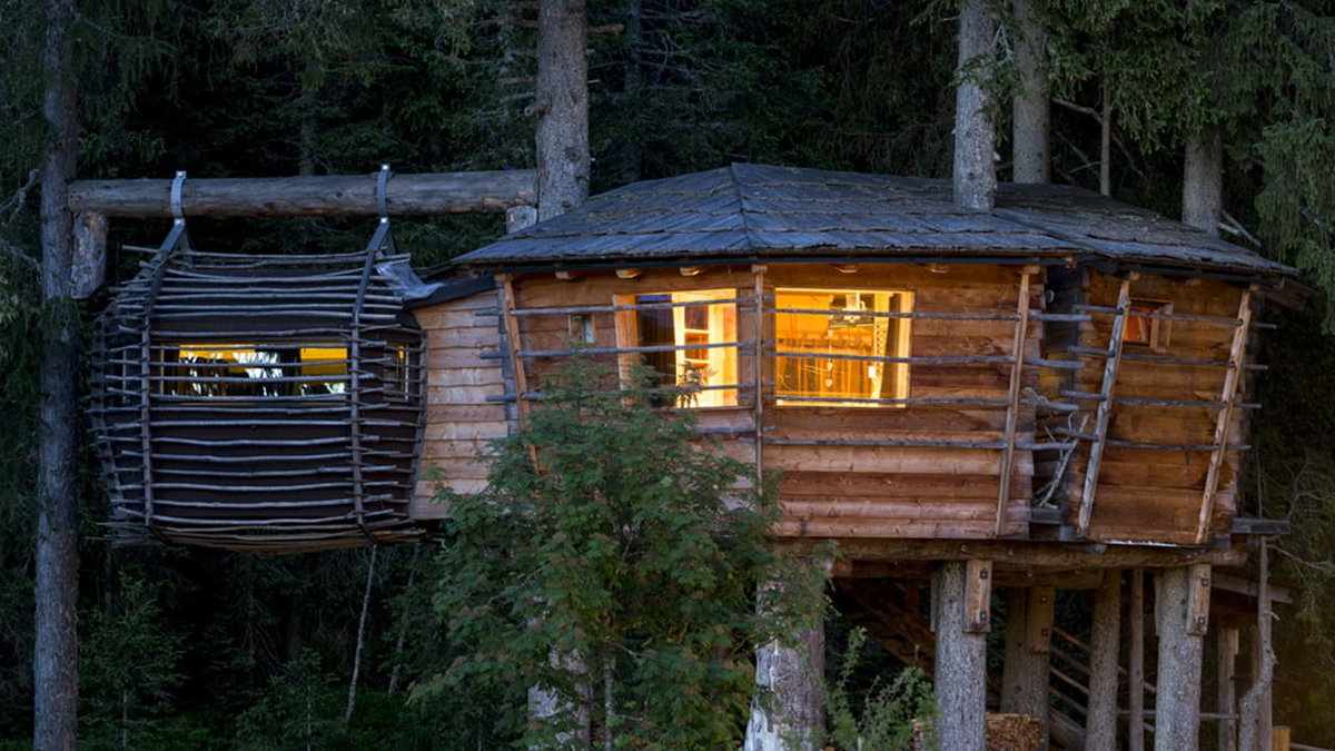 Ein luxurioeses Baumhaus im Caravan Park Sexten bei Nacht beim Glamping in Italien