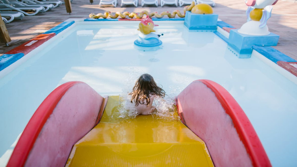 Ein Kind auf einer Wasserrutsche auf einem FKK Camping Platz in Frankreich