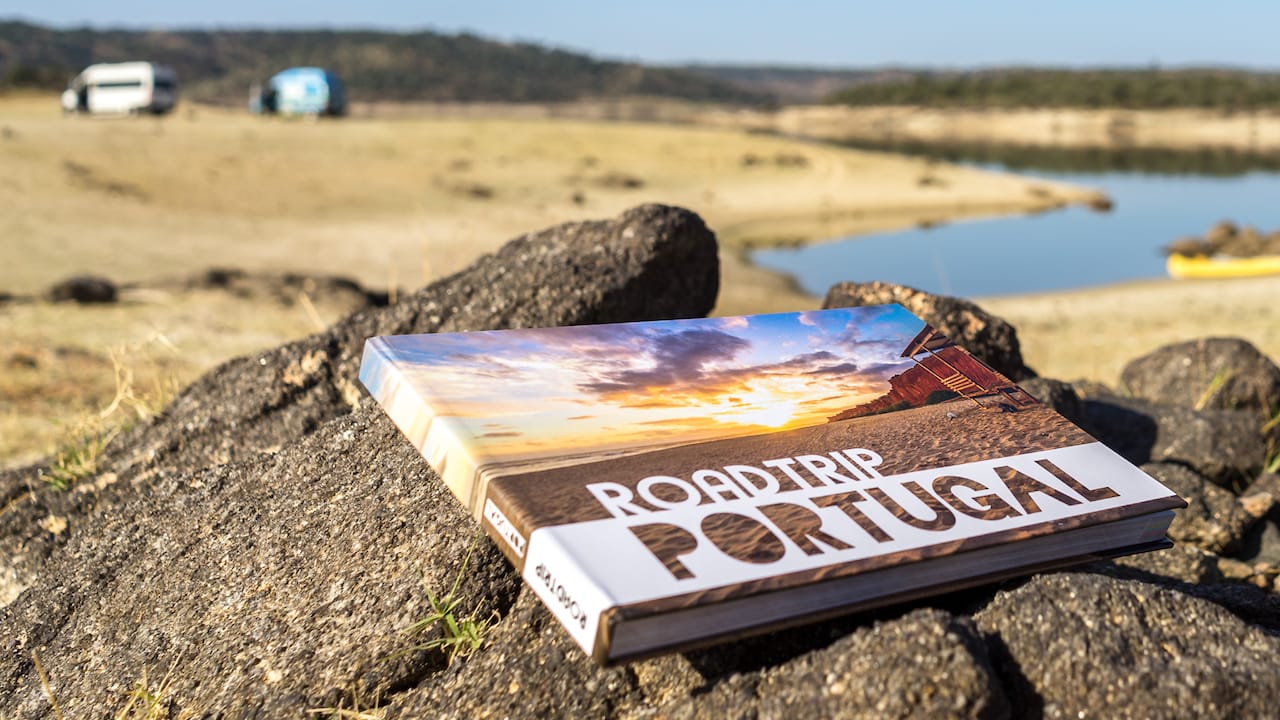 Ein Buch ueber Tipps und Informationen zu einem Roadtrip in Portugal auf einem Stein