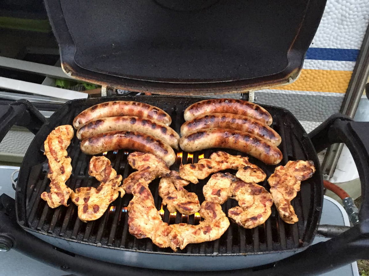 Würstchen und Hühnchen auf dem Gasgrill