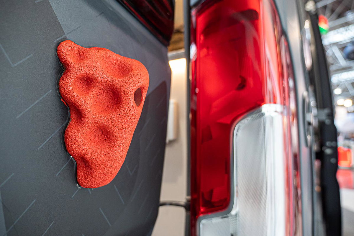 Nahaufnahme eines orangefarbenen Klettergriffes auf der Schiebetür des Sunlight Cliff 4x4 Adventure Van. Foto vom Caravan Salon 2019