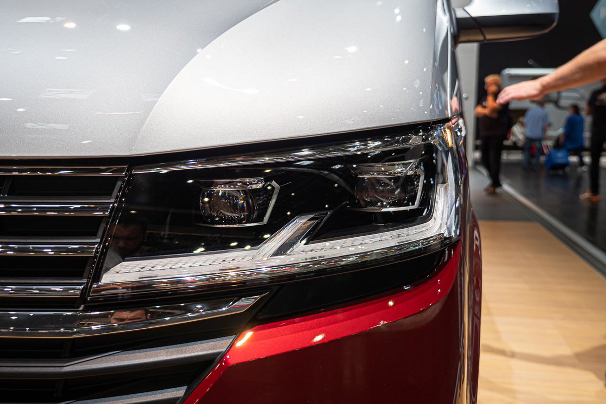 Nahaufnahme des linken Frontscheinwerfers vom VW California 6.1 Beach Camper auf dem Messestand des Caravan Salon 2019 in Düsseldorf