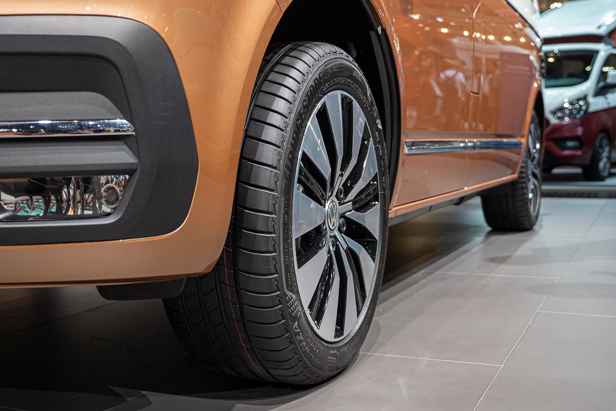 Nahaufnahme von vorne seitlich von einem linken Vorderreifen eines VW California 6.1 Oceanauf dem Messestand des Caravan Salon 2019 in Düsseldorf