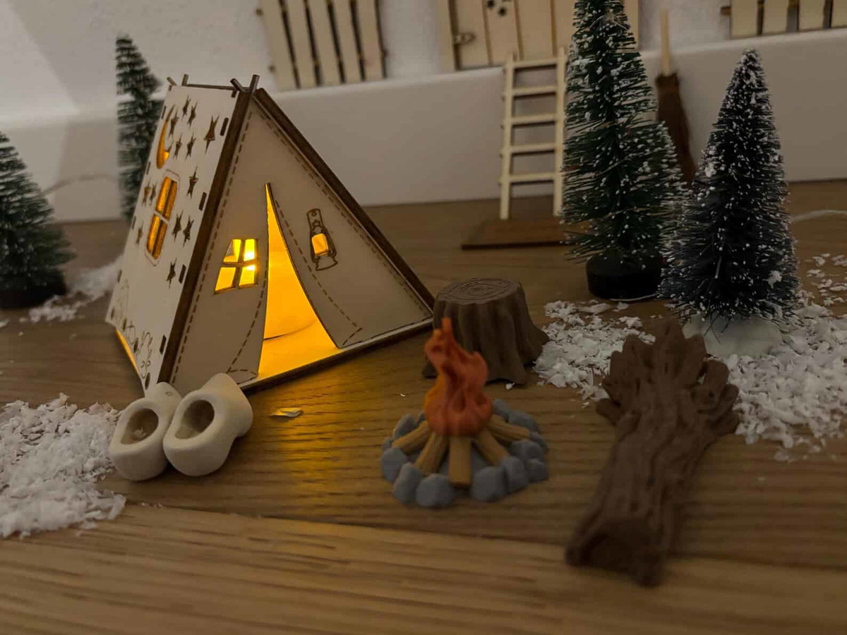 Stimmungsvolle Camping-Deko mit kleinen Bäumen, Feuerstelle &amp; Naturmaterialien, perfekt für Camperstyle.