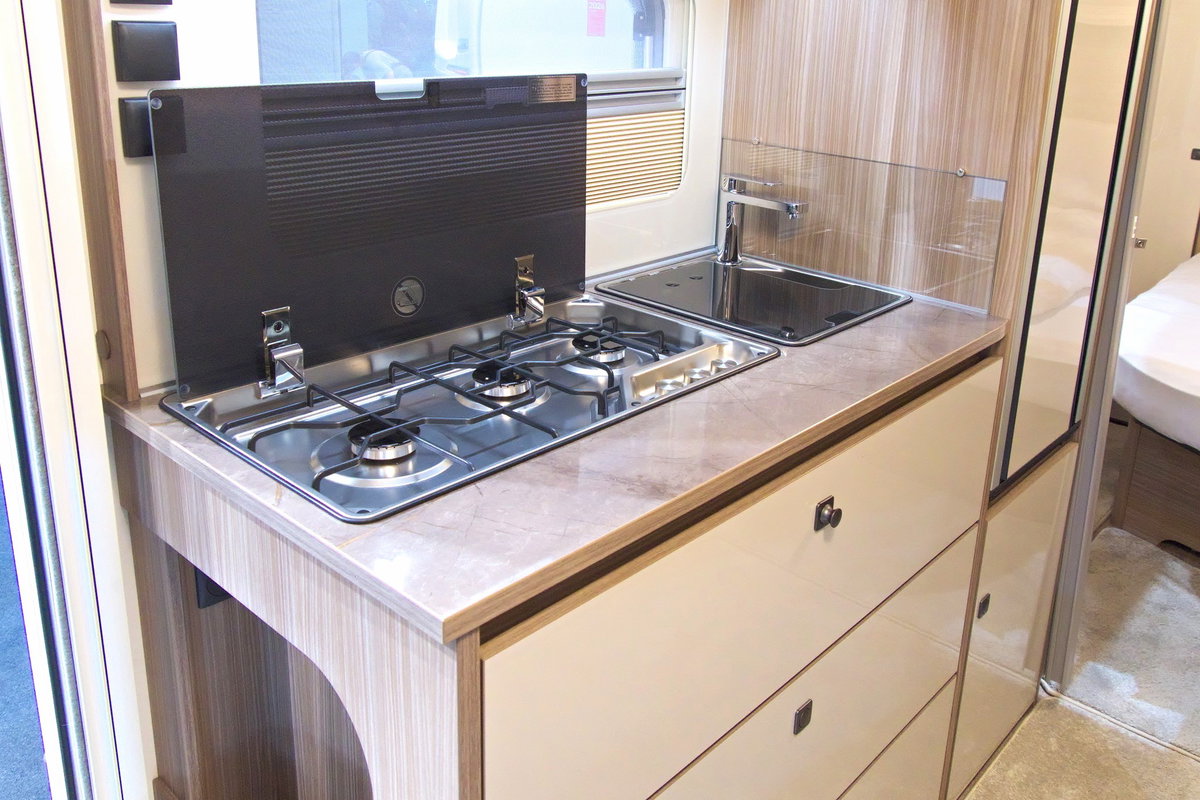 Fendt Tendenza 560 SFDW auf dem Caravan Salon 2026: Küchenzeile mit 3-flammigem Herd, Spüle sowie Kühlschrank und Stauraum.