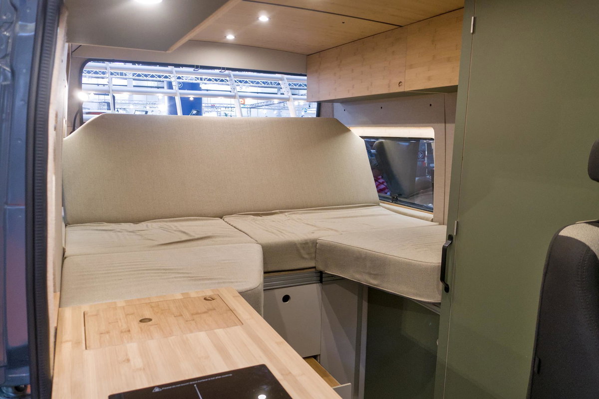 Kompanja ZWEI-L auf dem Caravan Salon 2026: Bett im Heck, zum Sofa umfunktioniert.