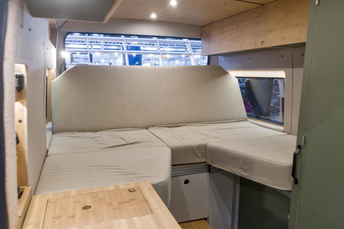 Kompanja ZWEI-L auf dem Caravan Salon 2026: Bett im Heck, zum Sofa umfunktioniert.