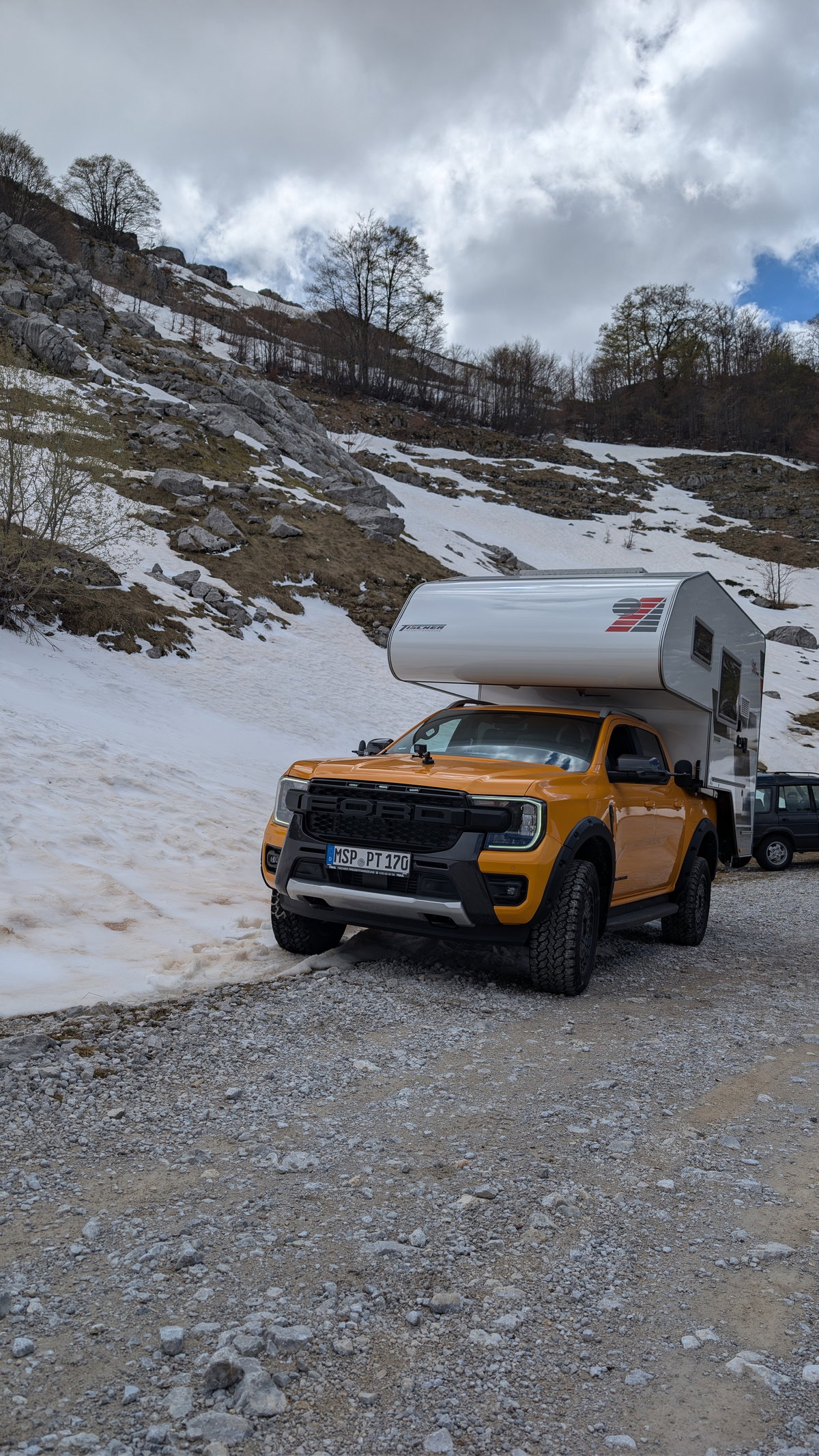 Pickup mit Wohnkabine auf einem verschneiten Pass in Montenegro