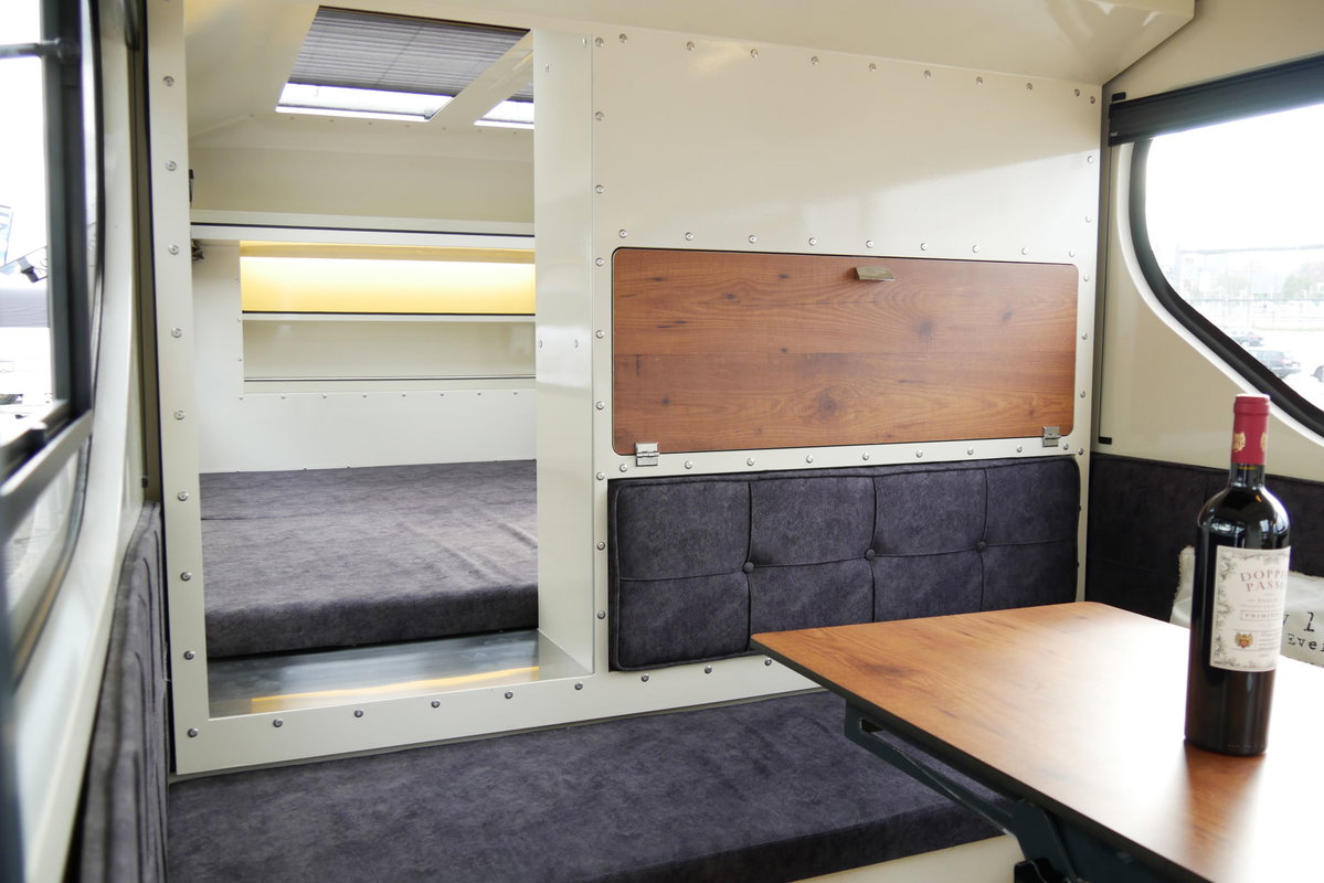 Raptor XC (3. Gen.) auf der Caravan live 2026 in Freiburg: Sitzgruppe und Doppelbett im Hintergrund.